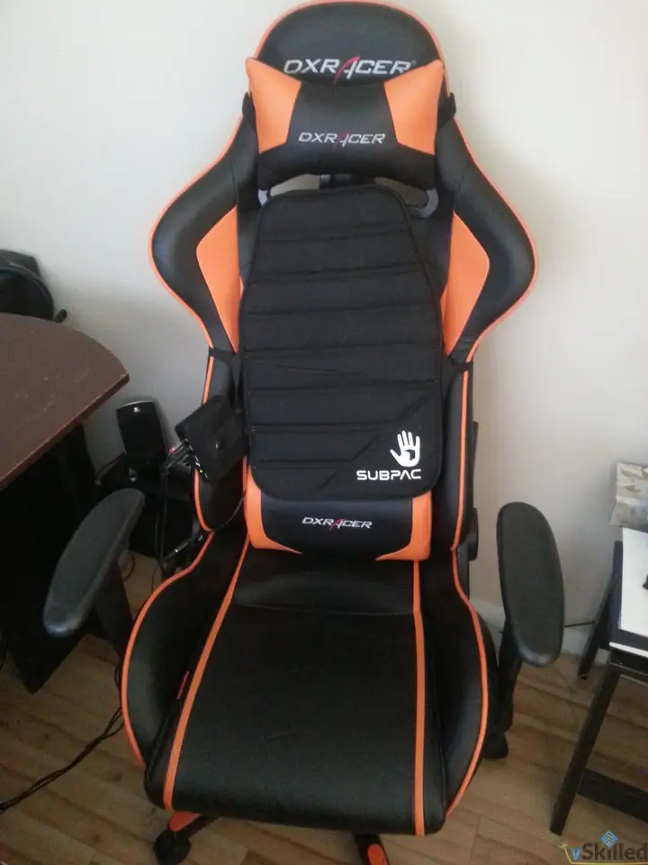 SubPac S1 tactile bass cushion mounted on an orange and black DXRacer chair