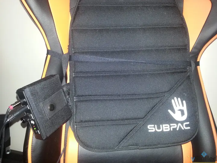 Close-up of the SubPac cushion and its controller beside the chair