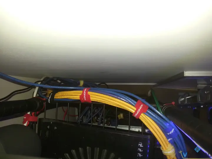 Yellow and blue network cables bundled along the back of the home lab shelf