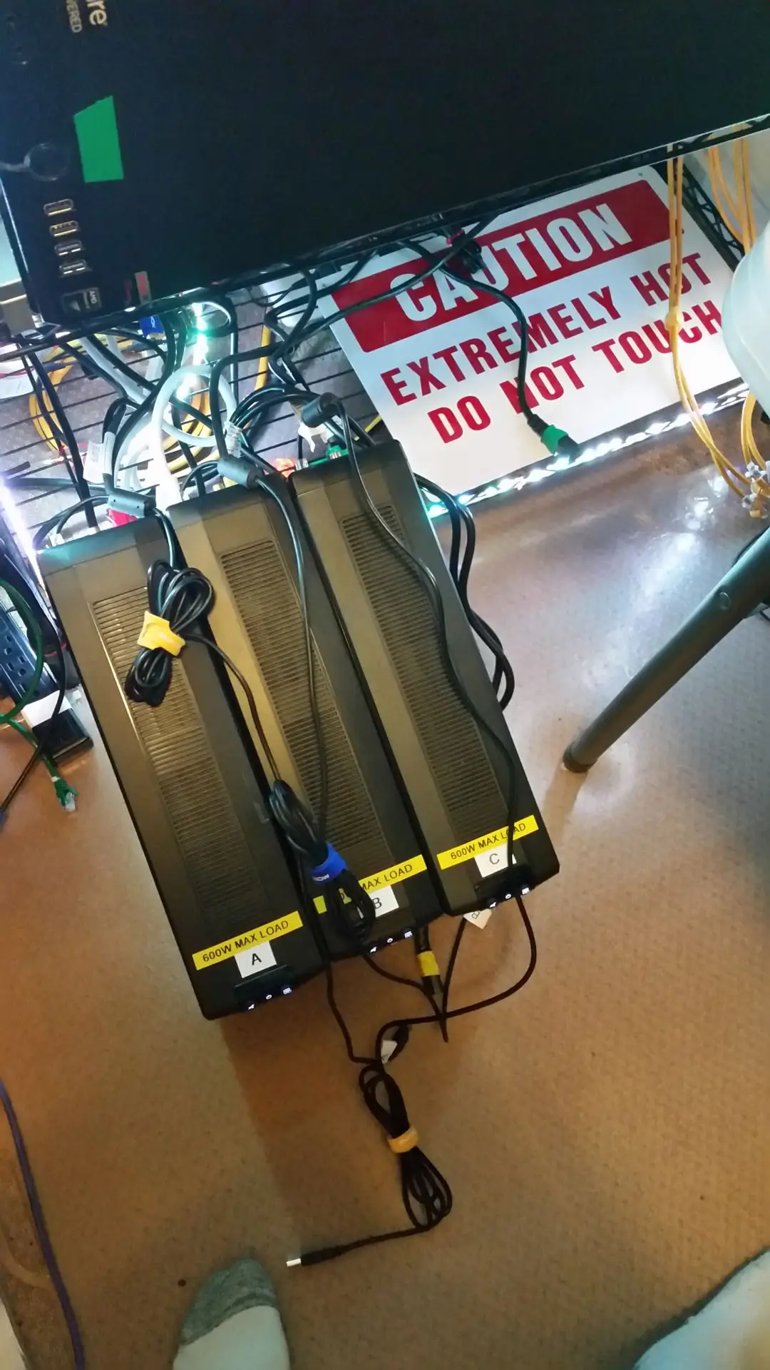 Three UPS batteries with yellow labels identifying their power feeds