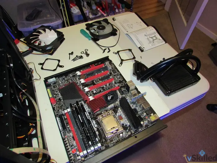 Motherboard, fans and liquid CPU cooler laid out on the workbench