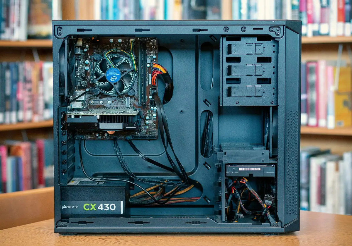 Open desktop computer case with internal components and empty drive bays