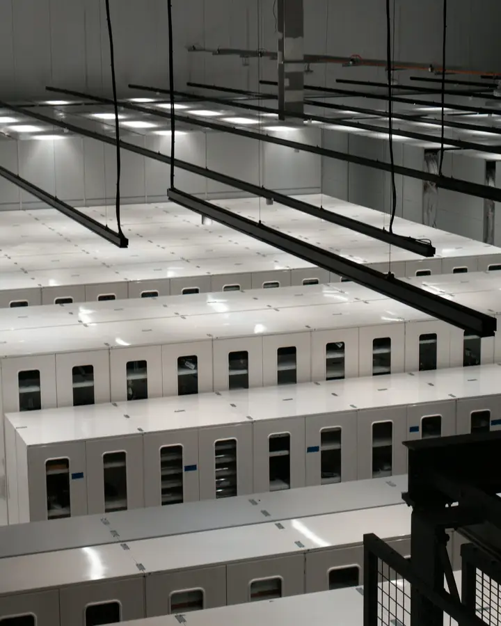 Rows of white server cabinets under overhead cable trays