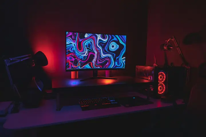 Gaming desk with a wide monitor and red accent lighting