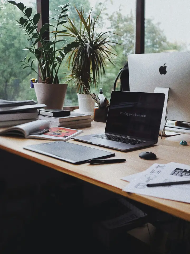 Laptop and open books arranged on a desk