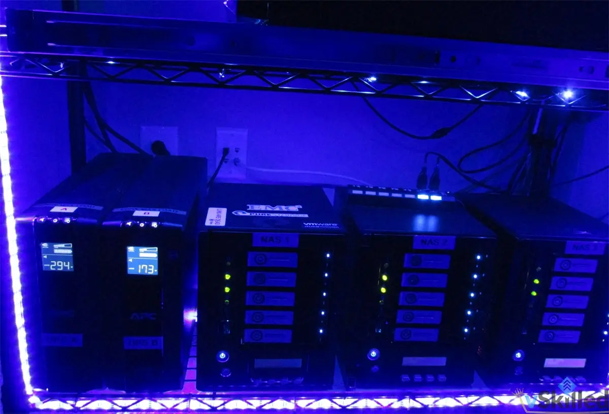 Three Thecus NAS units and UPS batteries on a blue-lit shelf