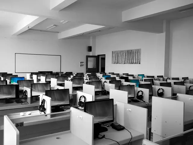 Rows of desktop computers and headsets in a computer lab