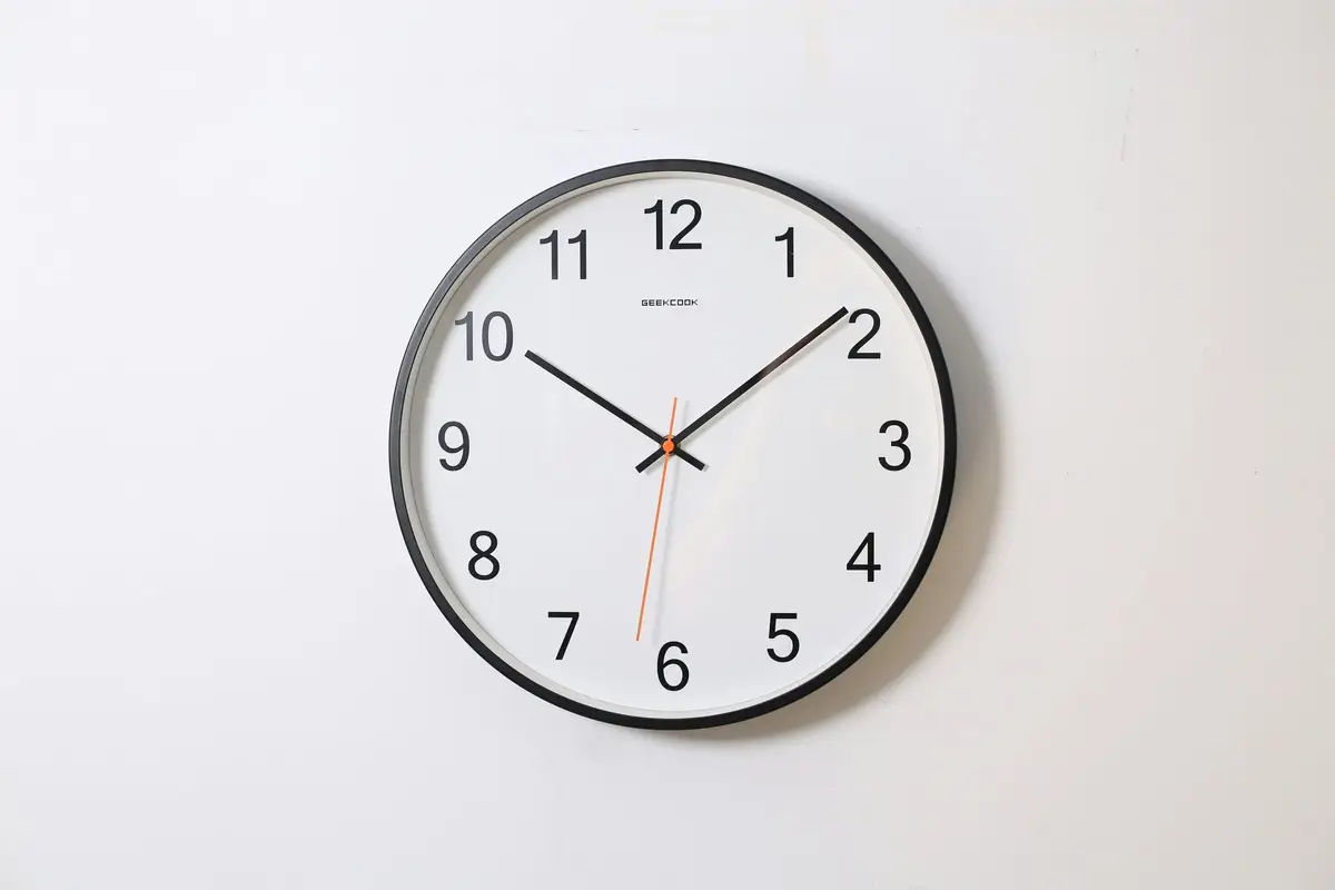 White analogue wall clock with black hands and numerals