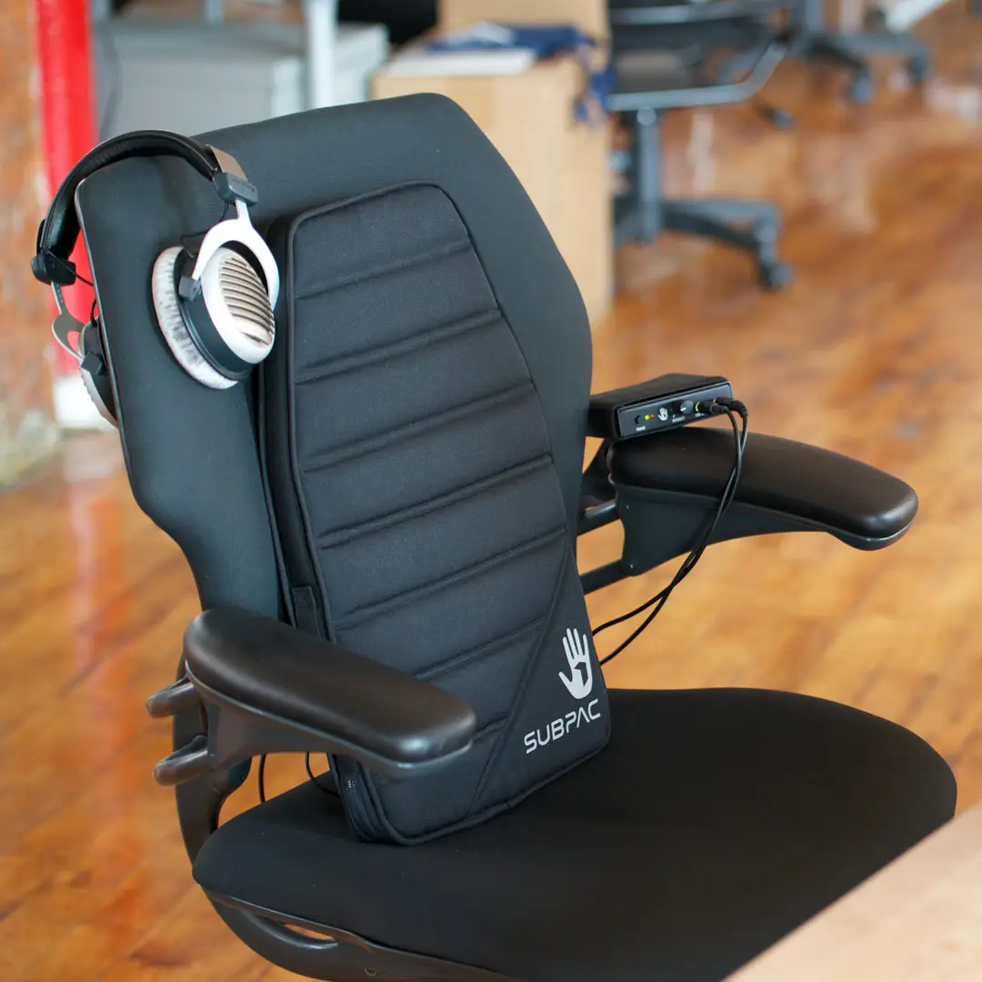 SubPac cushion and headphones attached to an office chair
