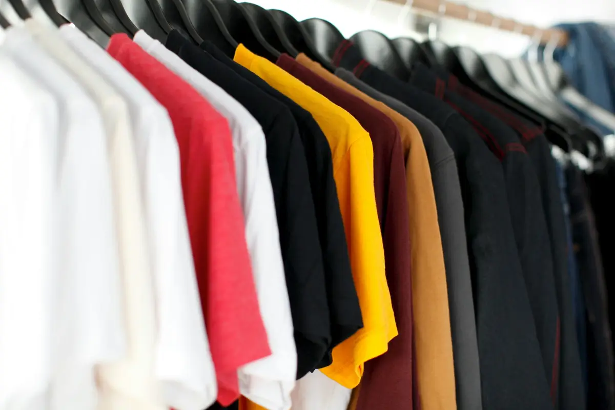 Plain T-shirts in several colours hanging on a clothes rail