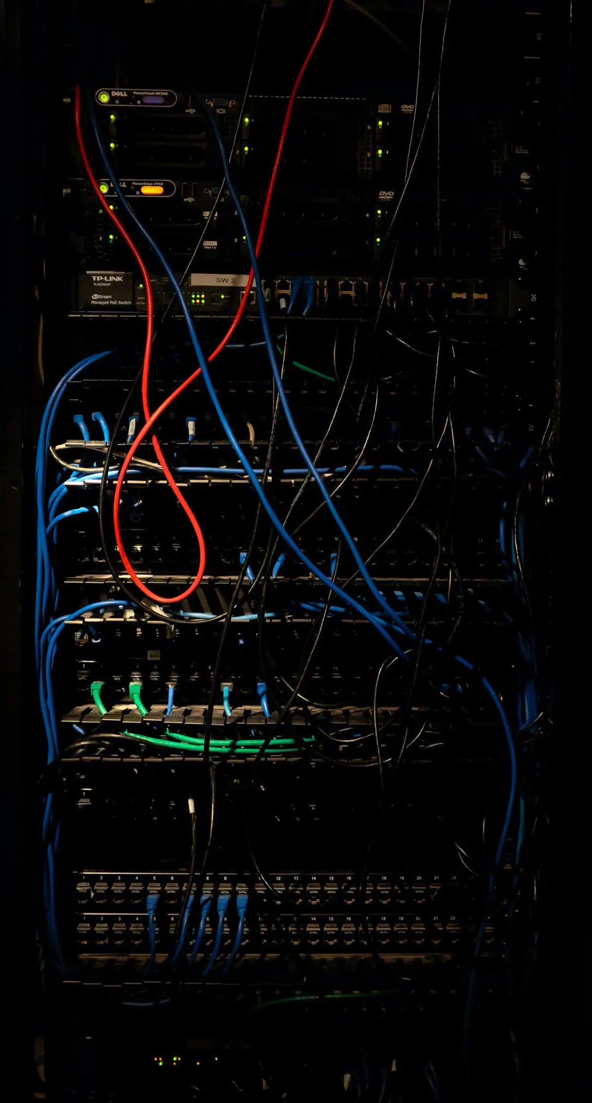 Server rack with red and blue patch cables between network equipment