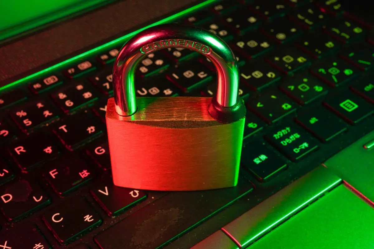 Red padlock standing on a backlit computer keyboard