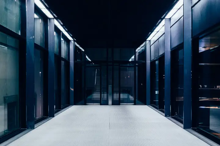 Empty data centre aisle between glass-fronted equipment cabinets